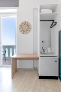 a white kitchen with a refrigerator and a table at Kumba At Koum Kapi in Chania Town