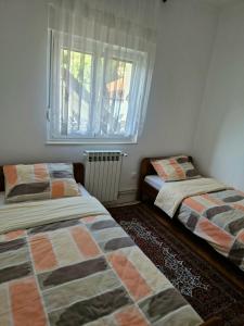 a bedroom with two beds and a window at Apartman Milija in Trebinje
