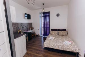 a small bedroom with a bed and a kitchen at Нові Apartments біля ЖД вокзалу in Ivano-Frankivsʼk