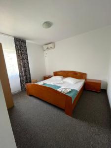 1 dormitorio con cama de madera en una habitación en Vila Mirela, en Eforie Nord