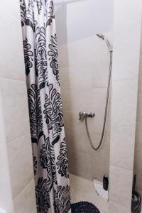 a shower with a black and white shower curtain at Нові Apartments біля ЖД вокзалу in Ivano-Frankivsʼk