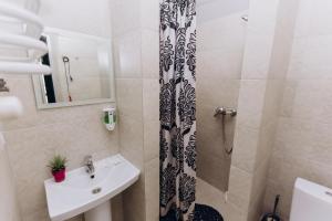 a small bathroom with a sink and a shower at Нові Apartments біля ЖД вокзалу in Ivano-Frankivsʼk