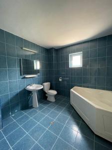 La salle de bains est pourvue d'une baignoire, de toilettes et d'un lavabo. dans l'établissement Vila Mirela, à Eforie Nord