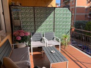 a balcony with two chairs and a table and flowers at casa RosAlina in Verona