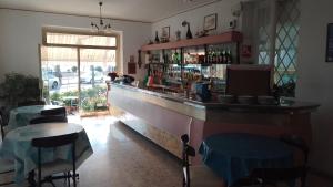 un bar in un ristorante con tavolo e sedie di Affittacamere Montecarlo a Laigueglia