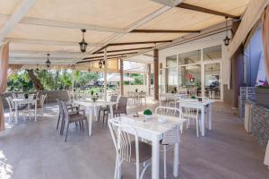 un restaurante con mesas blancas y sillas en un patio en Chrisa Hotel, en Limenas