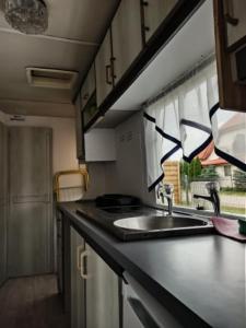 a small kitchen with a sink and a window at Dworek Łeba in Łeba