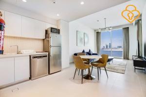 a kitchen and dining room with a table and chairs at Keysplease Spectacular Views Modern 1BR Creek Gate 602 in Dubai