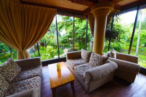 a living room with couches and a table and windows at Bali Garden Beach Resort in Kuta