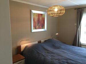 een slaapkamer met een blauw bed en een kroonluchter bij Huize Kruiz in Bellingwolde