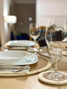 a table with plates and wine glasses on it at Lakeside apartment in Struga