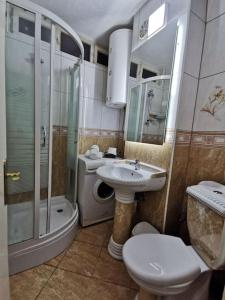 a bathroom with a sink and a shower and a toilet at Lakeside apartment in Struga