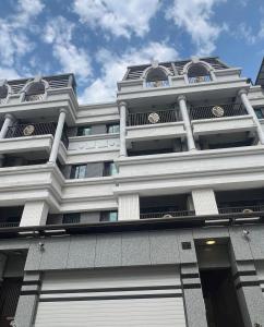 東港的住宿－龍貓親子民宿，一座高大的白色建筑,有很多窗户