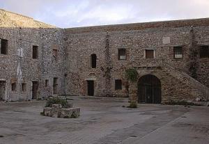 a large brick building with a door and a courtyard at B&b Irma in Olivarella