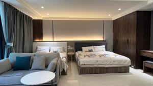 1 dormitorio con sofá, cama y mesa en Panda Homestay, en Donggang