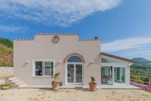 una piccola casa rosa con piante di fronte di Villa Belvedere by HelloElba a Rio nellʼElba