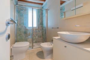 e bagno con servizi igienici, lavandino e doccia. di Villa Belvedere by HelloElba a Rio nellʼElba