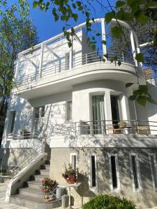 a large white house with stairs in front of it at Casa Cuniolo Guest House in Tortona