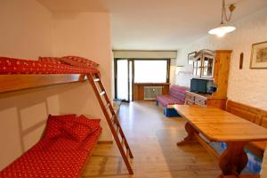 a living room with a bunk bed and a table at Nardis Studio 15 in Madonna di Campiglio