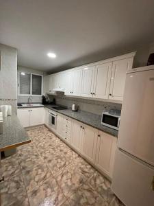 una cucina con armadietti bianchi e frigorifero bianco di Уютная квартира в Calpe a Calpe