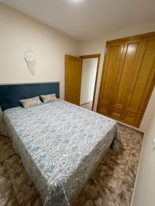 sypialnia z łóżkiem i drewnianą szafką w obiekcie Уютная квартира в Calpe w mieście Calpe