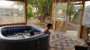 a couple of children playing in a hot tub at חאן בכפר במשק בלה מאיה - האוהל in Nevatim