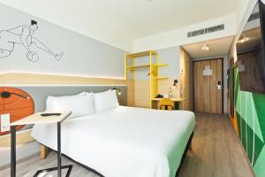 a hotel room with a bed and a desk at IBIS Styles Kaunas Centre in Kaunas