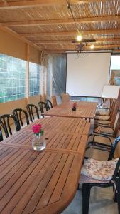 une salle de conférence avec une grande table et des chaises en bois dans l'établissement חאן בכפר במשק בלה מאיה - האוהל, à Nevatim