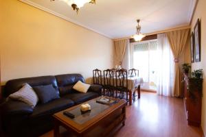 ein Wohnzimmer mit einem Sofa und einem Tisch in der Unterkunft Acogedor piso de 6 camas in Salamanca