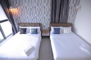 two beds sitting next to each other in a room at Cozy Haven Atlantis with Large Swimming Pool in Melaka