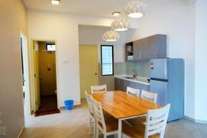 a kitchen with a wooden table and a refrigerator at Cozy Haven Atlantis with Large Swimming Pool in Melaka
