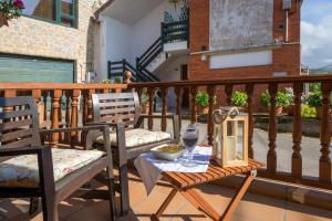 einen Balkon mit 2 Stühlen und einem Tisch mit einer Schüssel Essen in der Unterkunft CASA GERRA COMILLAS in Comillas