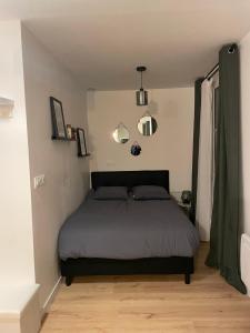 1 dormitorio con 1 cama y 2 luces en la pared en Studio de Provins en Provins