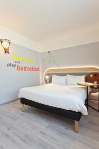 a bedroom with a bed and a sign that says keep calm play catch basketball at IBIS Styles Kaunas Centre in Kaunas