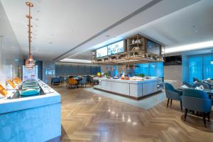 a restaurant with blue walls and a counter and chairs at Crowne Plaza Hangzhou Linping, an IHG Hotel in Hangzhou