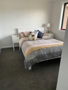 a dog sitting on a bed in a bedroom at Killara Kottage in Tumut