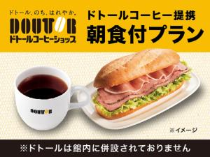 長岡市にあるHOTEL LiVEMAX 新潟長岡駅前のコーヒーの横の皿に盛ったサンドイッチ