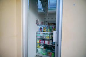 an open refrigerator door with food inside of it at RedDoorz Syariah near Unila in Bandar Lampung
