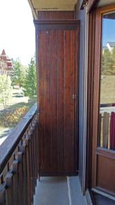 a porch with a wooden door next to a window at STUDIO AURON in Auron