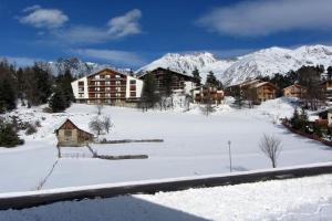 a resort in the snow with snow covered mountains at STUDIO AURON in Auron