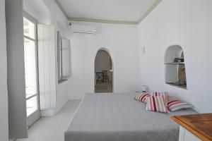 a bedroom with white walls and a bed with two pillows at Villa Hill-Ton in Arnados