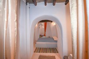 a small bedroom with a bed in an archway at Villa Hill-Ton in Arnados