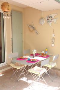 tavolo da pranzo con sedie e tavolo con cibo di Maldives YourHostHelper a Saint-Cyr-sur-Mer