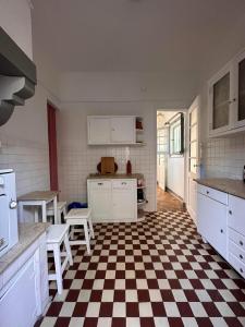 - une cuisine avec un sol en damier et des appareils électroménagers blancs dans l'établissement Lisbon Sea and City, à Trafaria