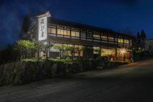 a building with a sign in front of it at night at Iroriyado Hidaya in Takayama