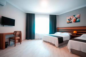 um quarto de hotel com duas camas e uma televisão em MiLAROOM em Edirne