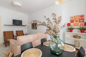 a vase with flowers on a table in a living room at Apartamento Azonaicas in Córdoba