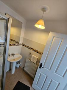 een badkamer met een wastafel, een toilet en een deur bij Laverty's - The Black Bull Inn in Randalstown