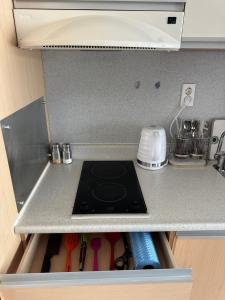 a kitchen counter with a stove top in a drawer at Hongdae Guesthouse 1min from Hongik Uni station Exit #1 in Seoul