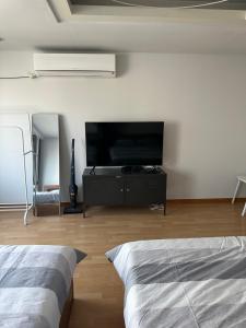a bedroom with a flat screen tv and a bed at Hongdae Guesthouse 1min from Hongik Uni station Exit #1 in Seoul